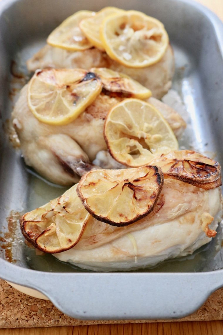 Oven dish with three chicken supreme pieces with lemon slices - portrait layout