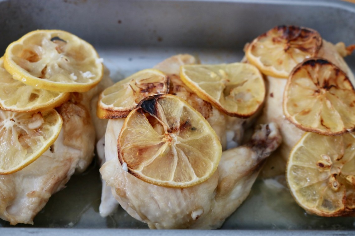 Oven dish with three chicken supreme pieces with lemon slices - landscape layout