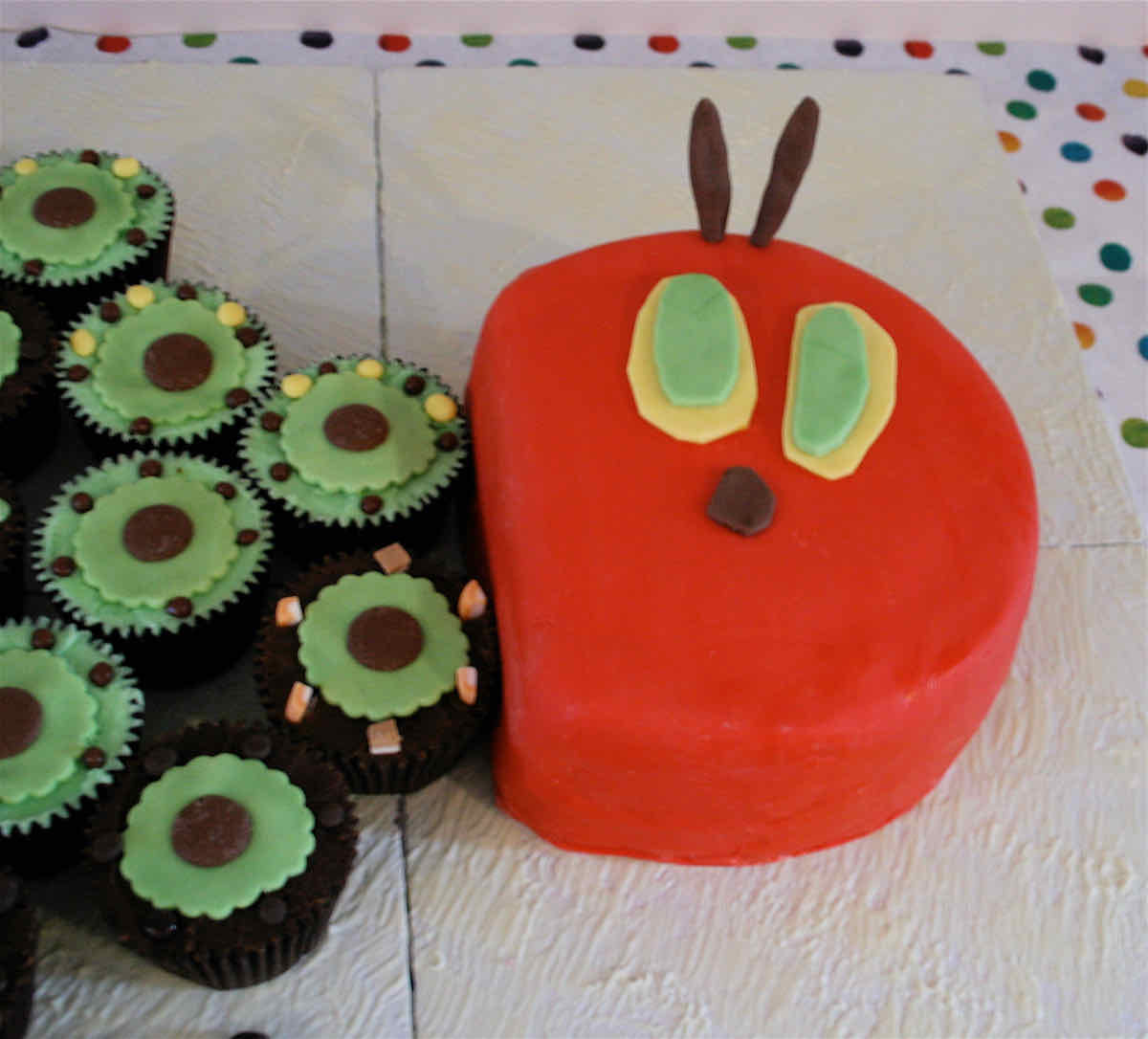 A cake depicting the head of The Very Hungry Caterpillar