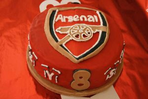 Red sugar paste covered cake decorated with the Arsenal Football team badge.