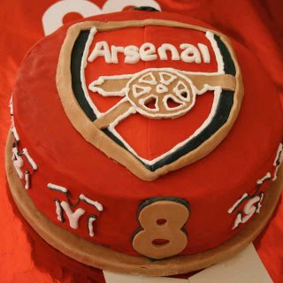 Red sugar paste covered cake decorated with the Arsenal Football team badge.