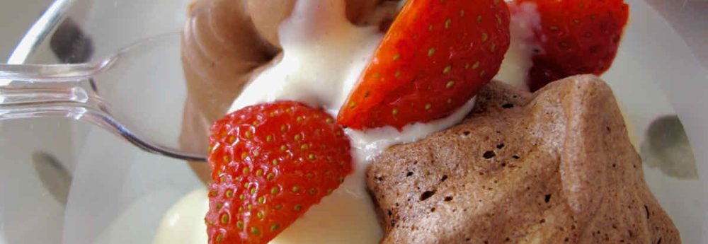 Dessert pot of mini chocolate meringues with creme anglais and strawberries