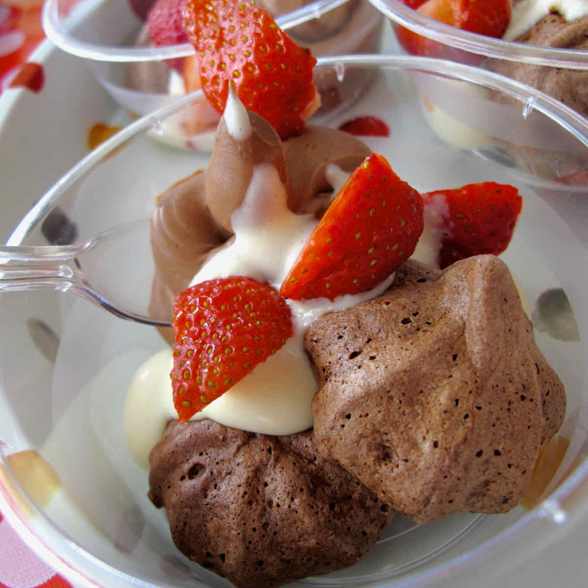 Dessert pot of mini chocolate meringues with creme anglais and strawberries