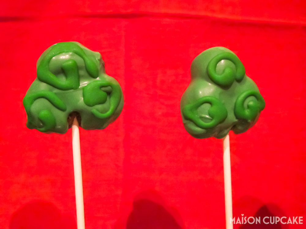 Two Green Shamrock Cake Pops on Red background