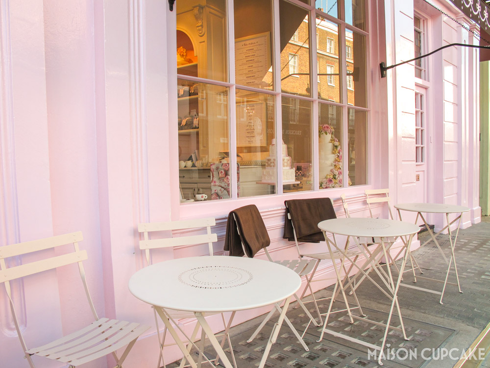 Outdoor Cafe tables and brown blankets on white metal chairs at Peggy Porschen pink parlour cafe London 2011