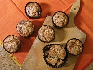 Pear and Ginger muffins with spelt: on a wooden board with orange background