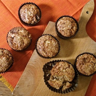 Pear and Ginger muffins with spelt: on a wooden board with orange background