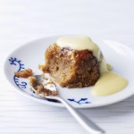 Sticky Toffee Pudding (Weight Watchers), a serving of golden brown pudding on a white plate with a spoon and custard