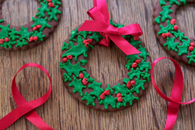 Christmas Wreath Cookies with iced holly and berries and a red ribbon bow.