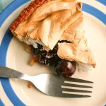 Cherry Meringue Pie, slice on cornish blue plate, close up portrait