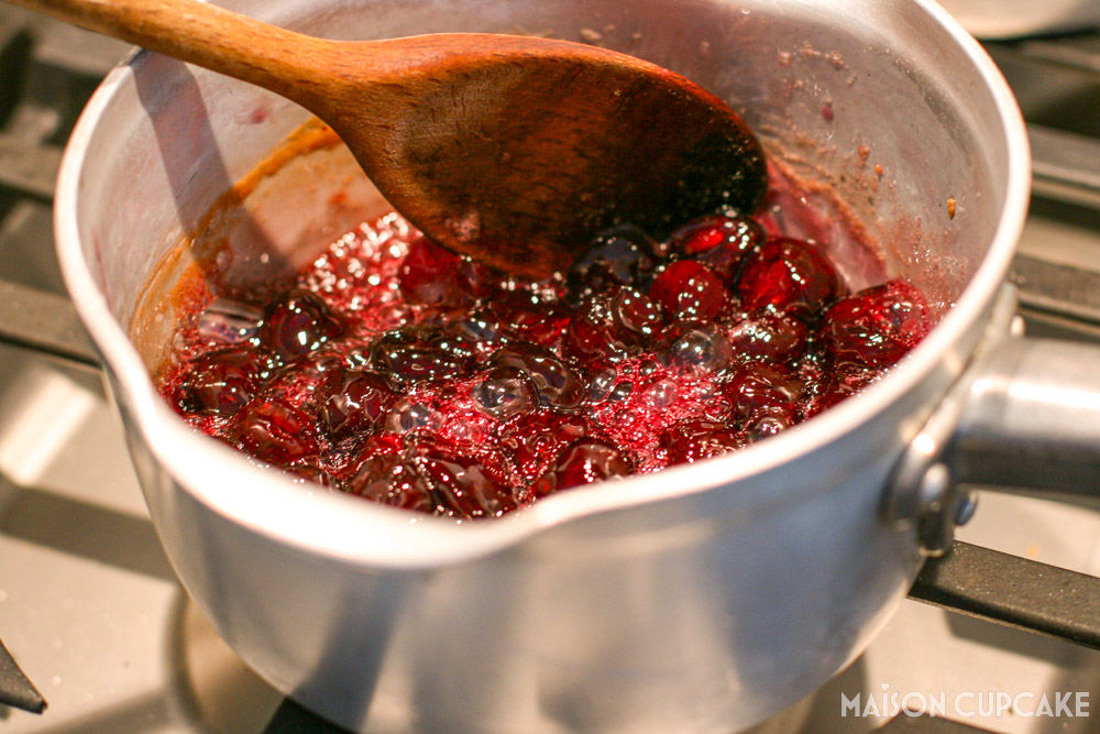 Simmering red cherries in saucepan