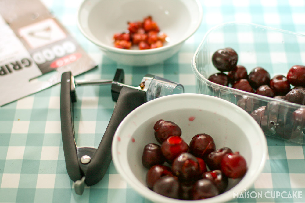 Pitted cherries in bowl with OXO cherry pitter tool