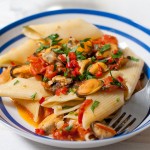 Pennoni chilli mussels - giant pasta recipe in a striped blue white bowl.