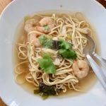 White bowl of tom yum prawn noodle soup recipe with fresh coriander garnish