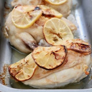 Oven dish with three chicken supreme pieces with lemon slices - portrait layout
