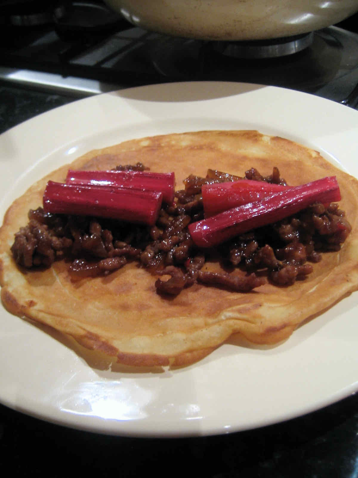 Assembling spicy pork pancakes with rhubarb