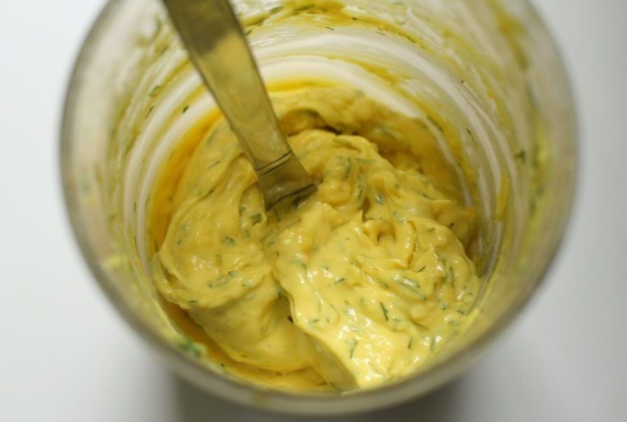 Bright yellow mayonnaise with flecks of dill