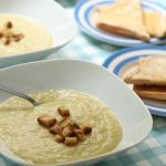 Leek and potato soup topped with croutons in white bowls