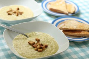 Leek and potato soup topped with croutons in white bowls