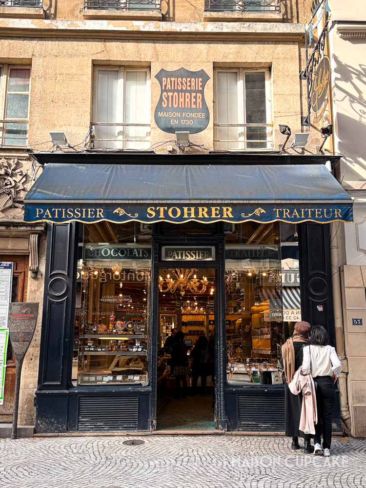 Exterior of Stohrer patisserie in Paris with navy awning.