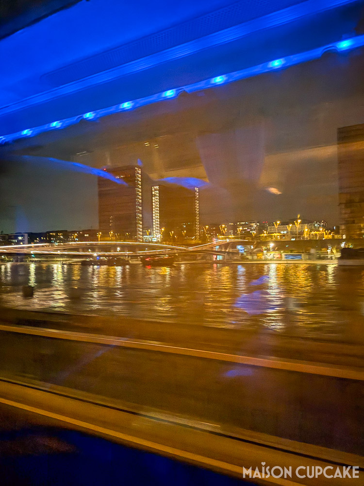 Night view of the Seine as seen from Paris to London Flixbus overnight coach, with blue lights inside bus window.