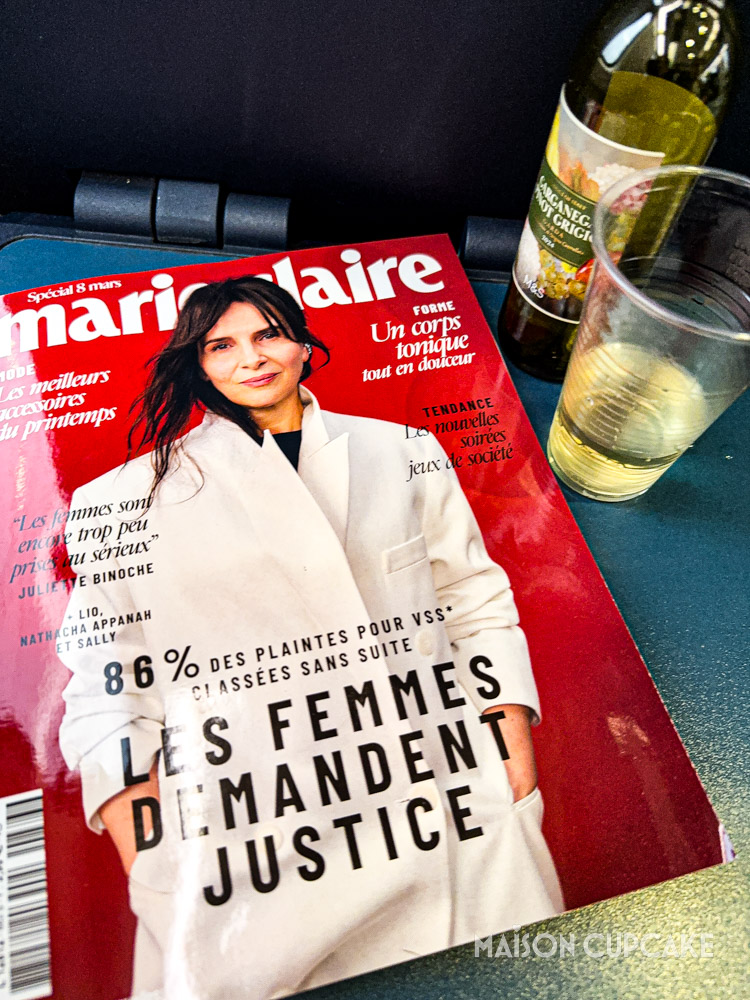 French copy of Marie Claire magazine with actress Juliette Binoche on cover with wine aboard Eurostar train.