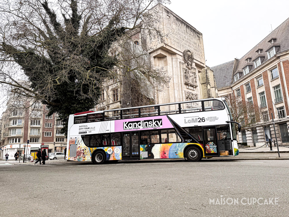 Double decker sightseeing bus parked beside Palais Rihour in central Lille.