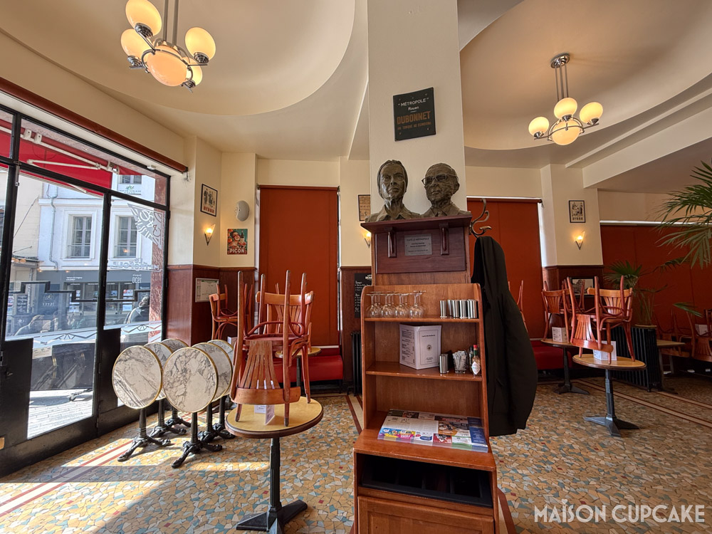Cafe interior with busts of Simone de Beauvoir and Jean-Paul Sartre in Rouen, France.