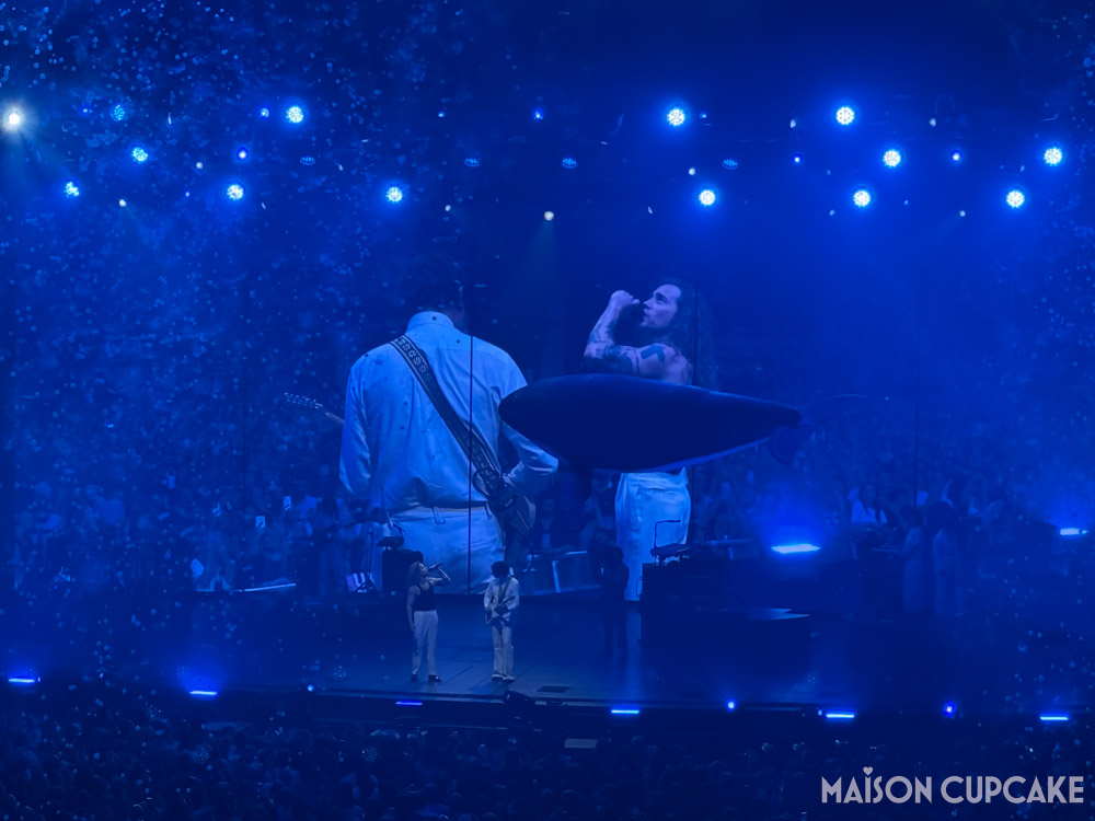 Julien Doré stageshow at Rouen Zénith, blue light fills the arena as an inflatable whale and bubbles float giving impression of being underwater.