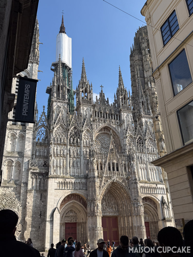 Gothic facade of Rouen cathedral on a sunny day, the fleche spire is covered with white tarpaulin during repairs.