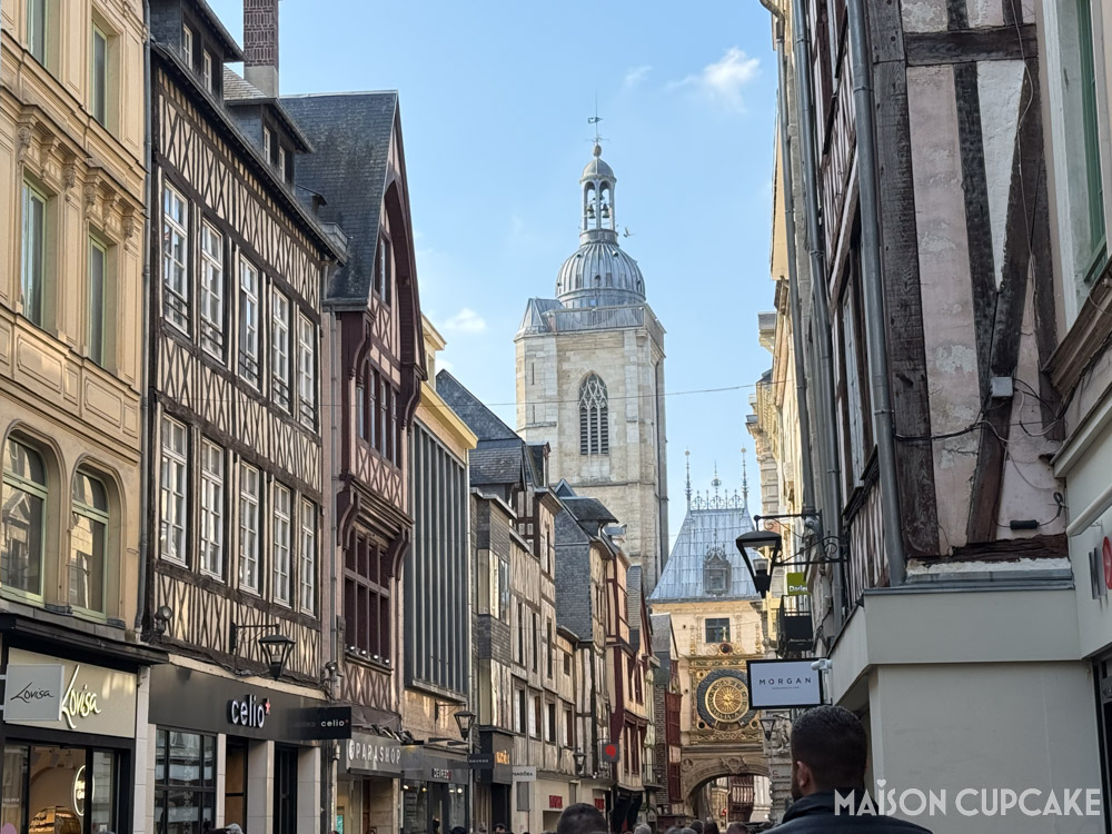 Rouen city break scene: shopping street with timber buildings and gros-horlogue medieval clock.